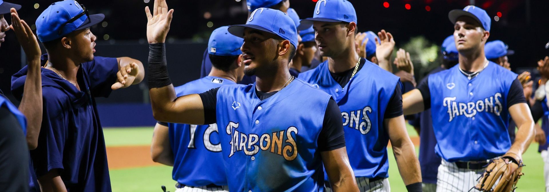 Tampa Tarpons players high-five.